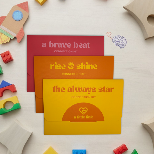 Three colorful boxes labeled 'a brave beat', 'rise & shine', and 'the always star' connection kits for children with separation anxiety