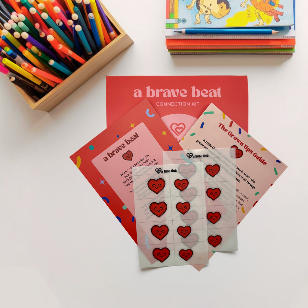 A Brave Beat connection kit flat lay with matching tattoos, tapping ritual card, and caregiver guide for kids’ calm and confidence